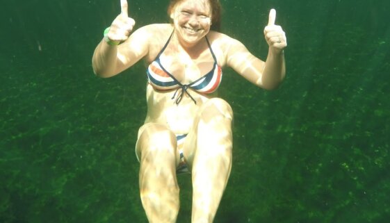 Photograph of Sophie Walker underwater smiling with thumbs up